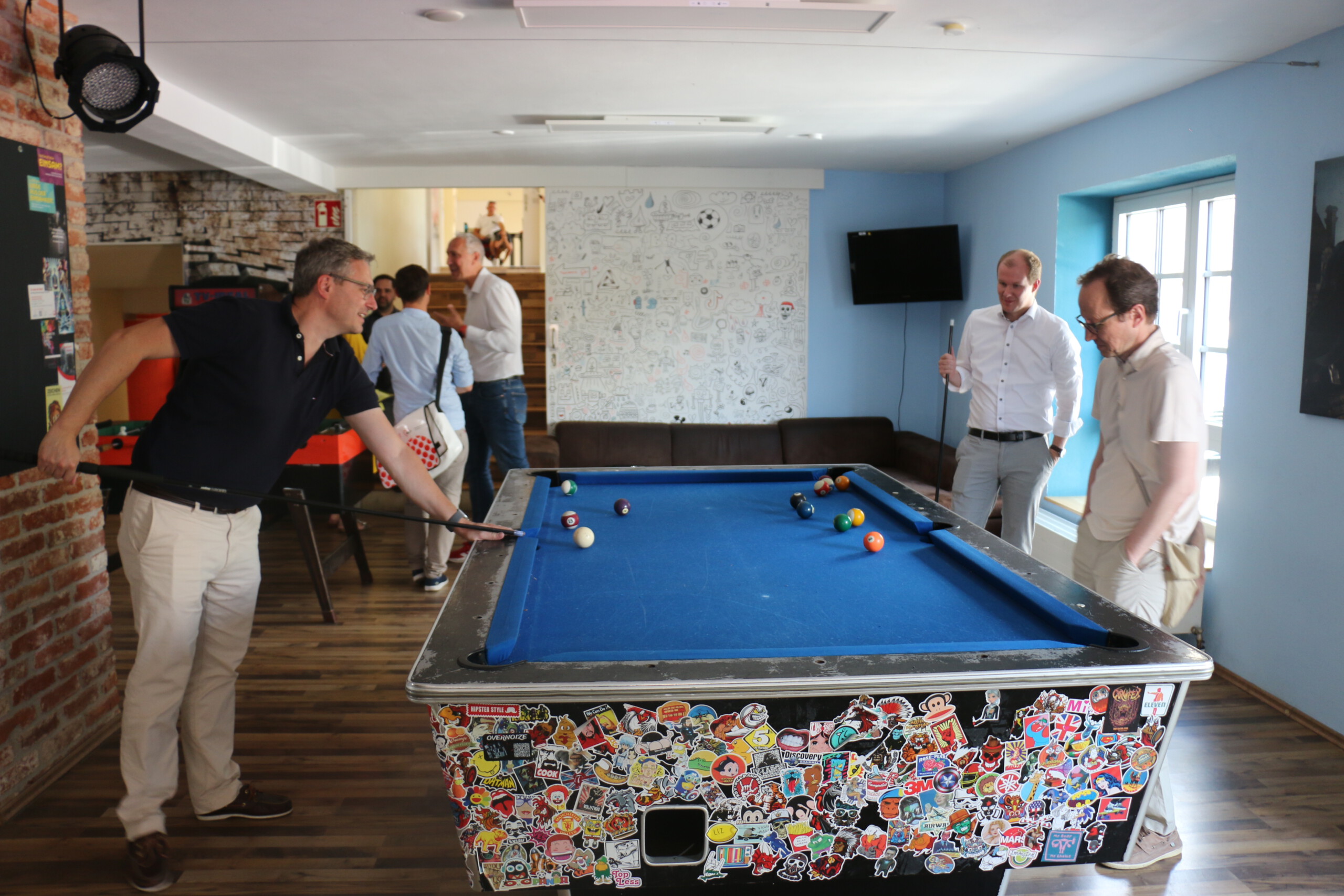 Drei Männer stehen und spielen an einem Billardtisch im Jugendhaus Wertingen